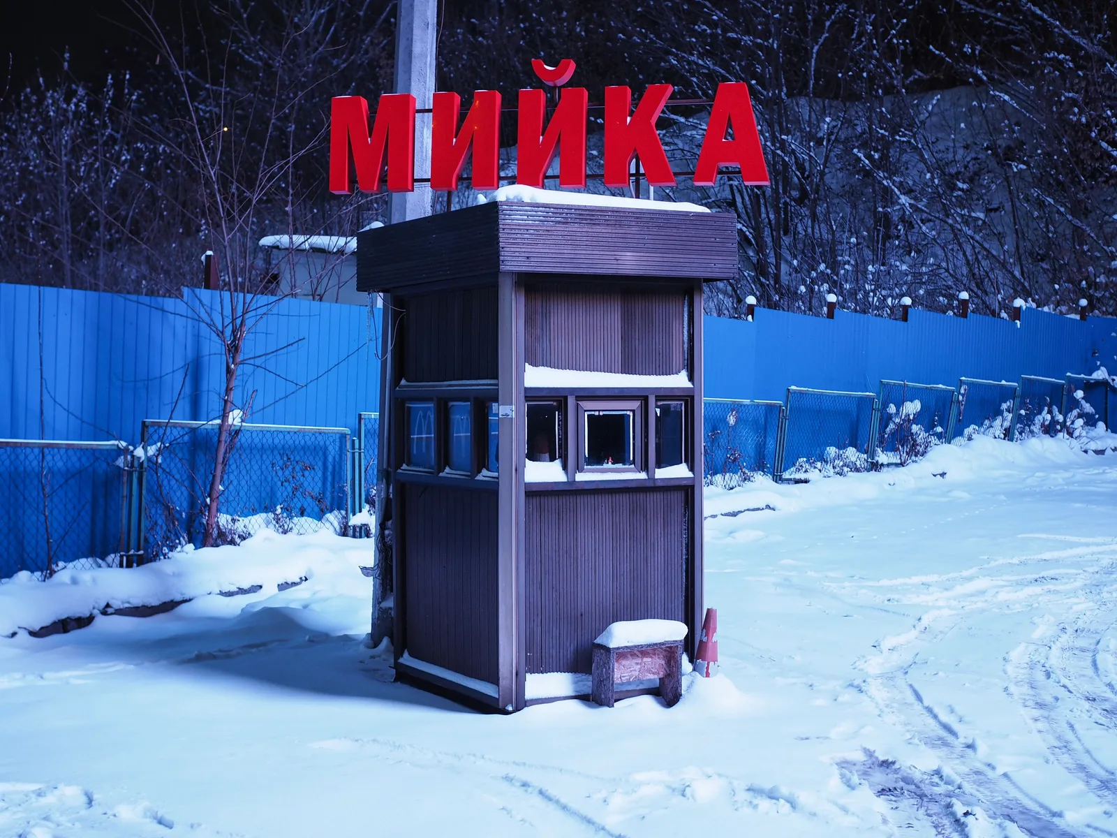 A wooden car wash hut in a snowy setting with a bold red sign, captured at night. Car Wash Pay Station Placement: Reduce Bottlenecks at the Entrance