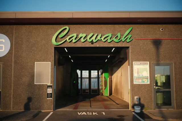 Exterior view of a carwash in Norway, featuring modern design and ambient sunset lighting. Car wash business location strategy: traffic, stacking and site checks